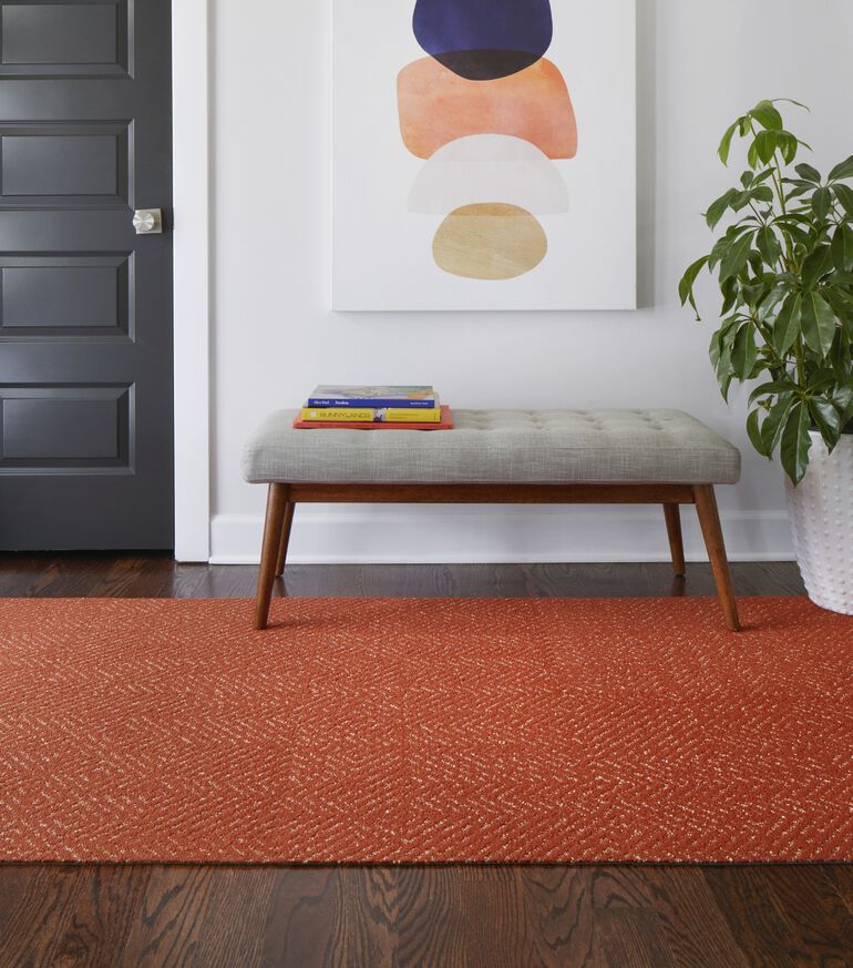 Foyer area with FLOR Open Invitation area rug shown in Orange with bench seating
